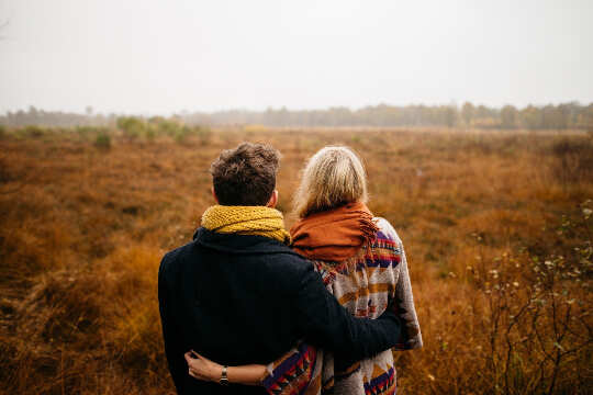 pasangan memandang ke padang rumput yang kosong