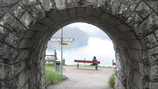 トンネルの終わりにあるベンチに座って、道標が左または右を向いている人