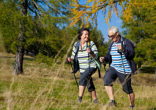 Pasangan yang lebih tua menggunakan kayu trekking semasa mengembara.