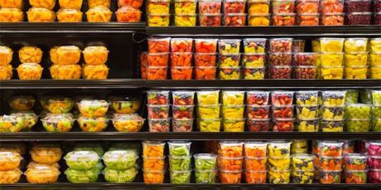 Sortiment av kuttet frukt i plastbeholdere på skjermen til salgs i supermarkedet