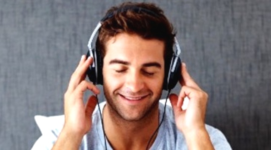 egy mosolygós fiatalember fejhallgatót viselő