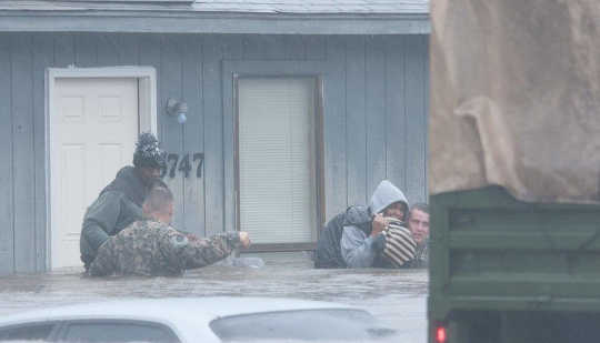 Tentara Nasional Garda membantu warga mengevakuasi rumah mereka di Fayetteville, North Carolina pada Oktober 8. US Army National Guard / Flickr, CC BY