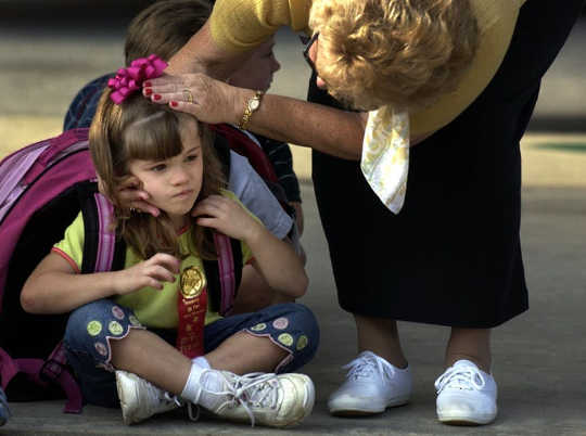 Teacher’s aide Sue Price, right, examines Ashlyn Blocker’s head for scrapes (Why do some people hurt more than others)