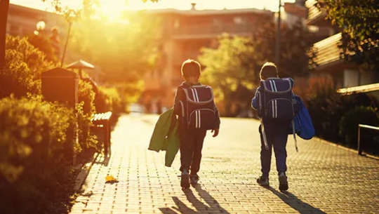 δύο νεαρά αγόρια περπατούν στον δρόμο από μόνα τους