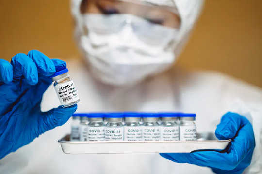 En forskare som håller injektionsflaskor med COVID-19-vaccin som kommer att användas i kliniska prövningar. (hur inbördeskriget drev medicinsk innovation och pandemin kunde också)