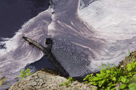 I rifiuti di fabbriche tessili scaricano in un affluente del fiume Citarum al di fuori di Bandung, Java, Indonesia, 2018.