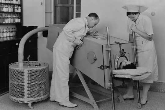 مريض شلل الأطفال في رئة حديدية لمساعدته على التنفس. (يُظهر التاريخ سبب كون الطريق إلى طرح اللقاح دائمًا وعرًا)