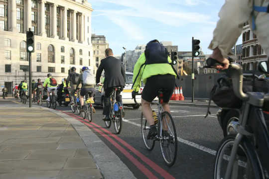 Пасажири на велосипеді їдуть на роботу.