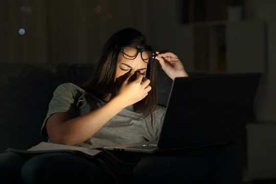 Geceleri dizüstü bilgisayar kullanan yorgun kadın