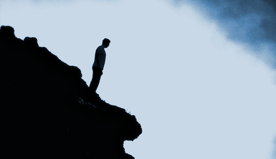 رجل يقف وحده على حافة منحدر