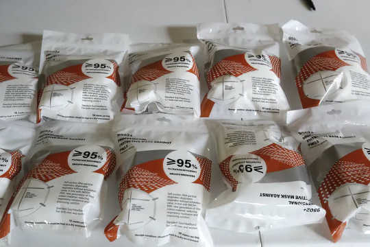 Een tafel met diverse merken KN-95 maskers in verpakking