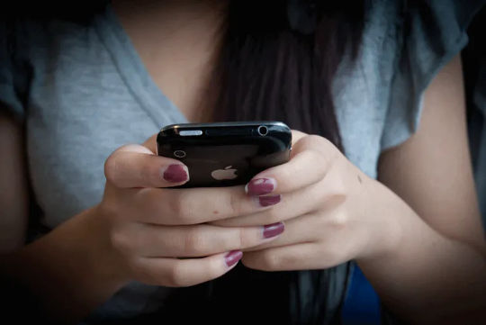 una mujer enviando mensajes de texto en su teléfono