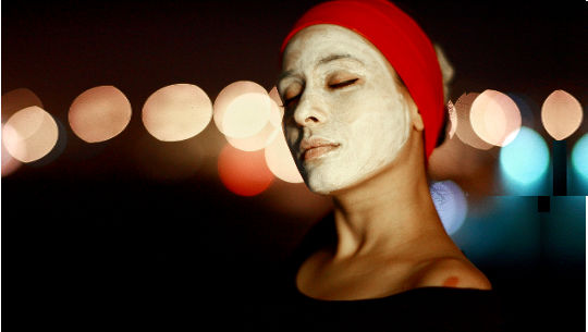 woman wearing a turban and with a mud or clay mask on her face