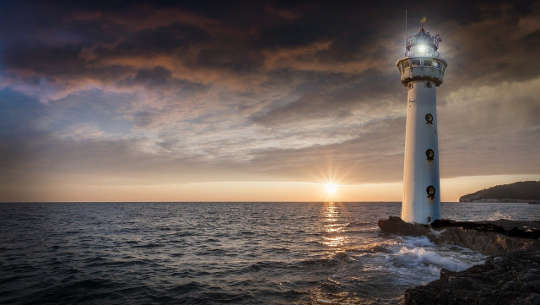 a világítótorony képe, amely megvilágítja az utat a vízen