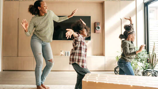 Mujer y niños bailando alegremente