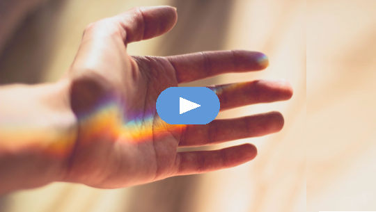 en regnbue i håndflaten på en åpen hånd