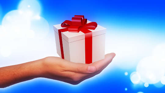 a small gift-wrapped package in an open hand