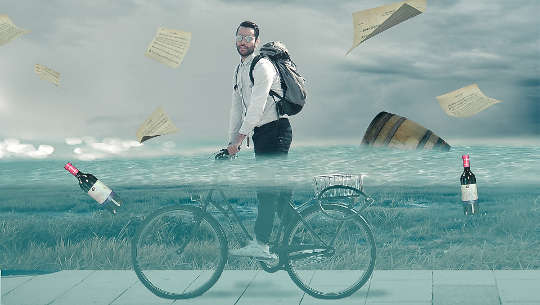bărbat care merge pe bicicletă prin apă de inundație înălțime de talie