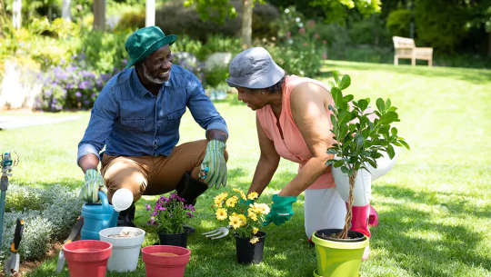 két ember beszélget és kertészkedik