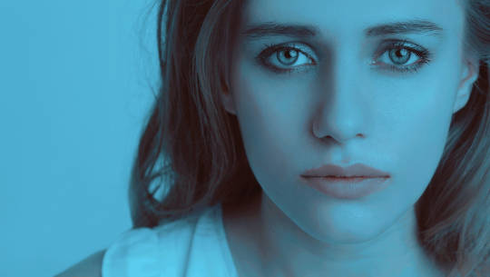 женское лицо, заштрихованное синим, с грустным видом