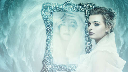 mujer frente a un espejo con un reflejo diferente en el espejo