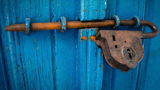 ett gammalt hänglås på en blå dörr
