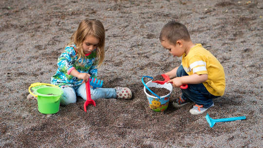 en ung pojke och flicka som leker i sanden