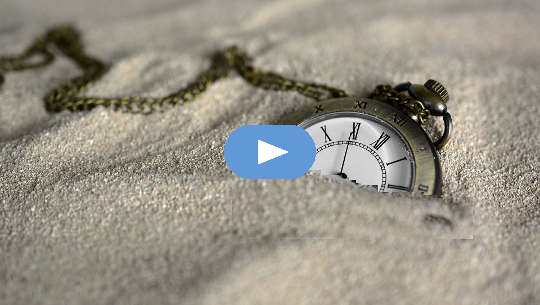 un orologio da taschino semisepolto nella sabbia