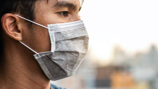 larawan ng taong nakasuot ng surgical mask na hindi nakatatak sa mga gilid