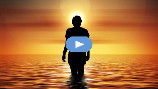 donna in piedi nell'oceano guardando il sole nascente