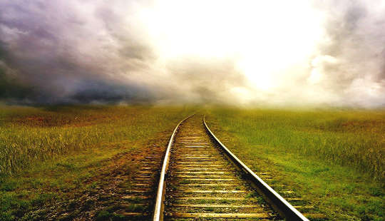 trilhos de trem levando para o horizonte distante