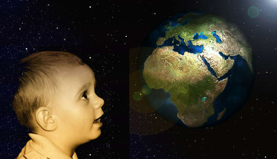 一个孩子抬头看着地球仪