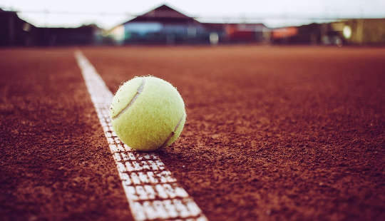 흰 선에 앉아 있는 테니스 공
