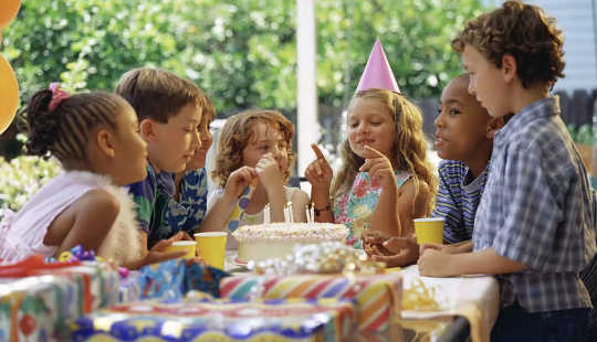 kinderen aan een tafel rond een verjaardagstaart