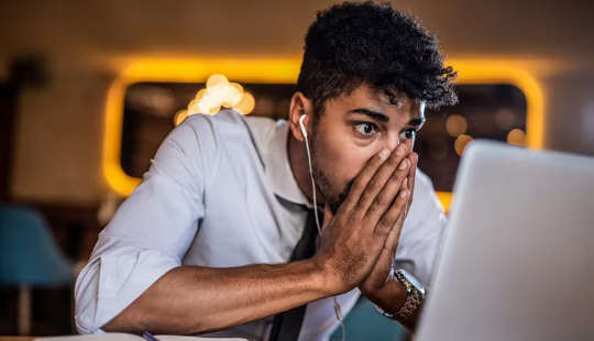 نوجوان اپنے کمپیوٹر اسکرین کے سامنے بیٹھا ہے۔