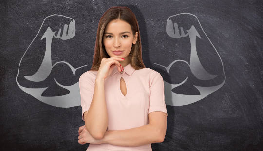 ung kvinde stående foran en tavle tegning af vægtløfter muskler
