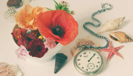 une nature morte avec des fleurs, une montre de poche et des coquillages