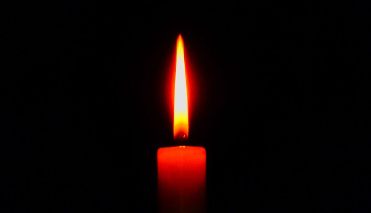 uma única vela vermelha com uma chama constante