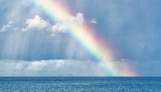 um arco-íris brilhando na água
