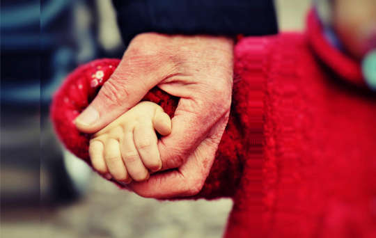 ένα μικρό παιδί που περπατά και κρατά το χέρι του πατέρα της