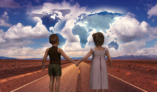 hai đứa trẻ nắm tay nhau trên con đường có thế giới trước mặt