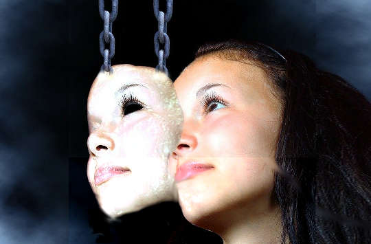 a mask held up by chains overlapping a woman's face