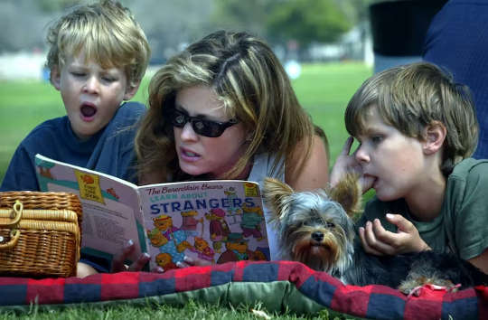 femeie care le citește la doi copii mici