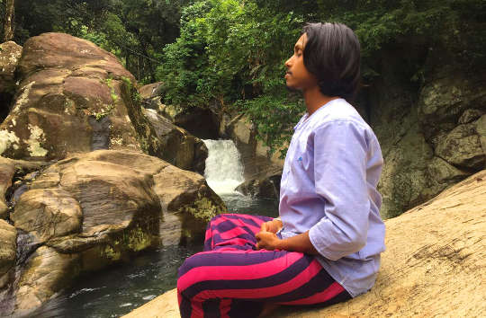 um jovem meditando fora