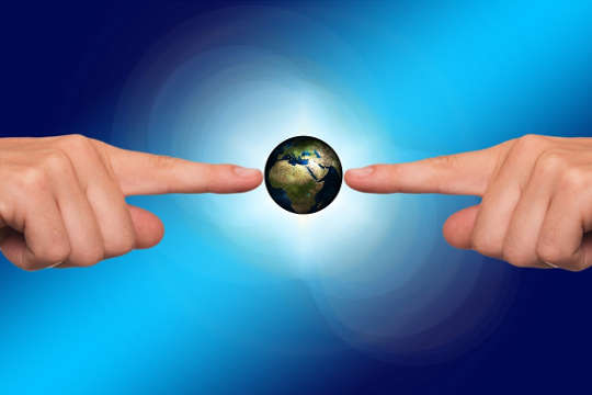 to hender som peker og berører planeten jorden