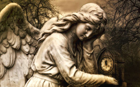 en staty av en ängel som håller i en klocka, med en tår som faller från ögat