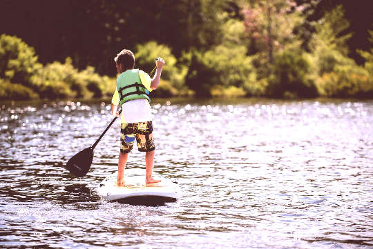um menino em um paddleboard