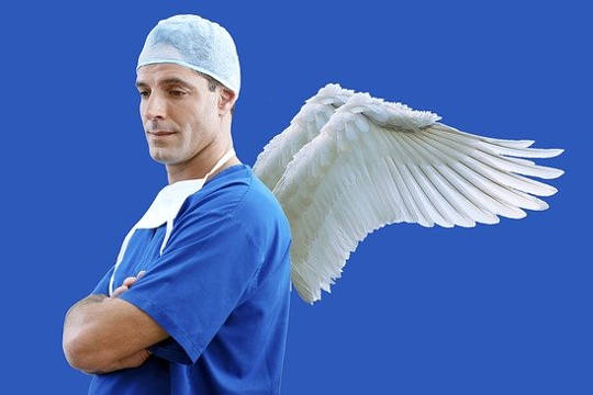 seorang doktor dalam scrub dengan sayap malaikat