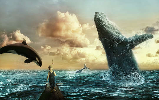 balenele de mare sar în sus cu un copil care urmărește