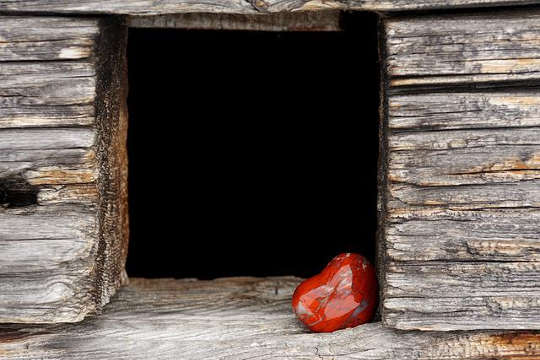 une image d'un coeur dans une ouverture de porte sombre